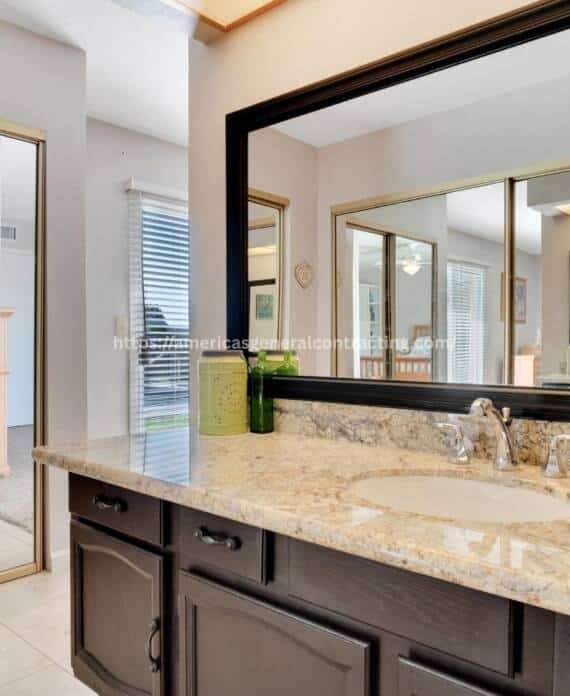 Stylish bathroom vanity with granite countertop, large mirror, and decorative accents, highlighting bathroom remodeling Dallas services