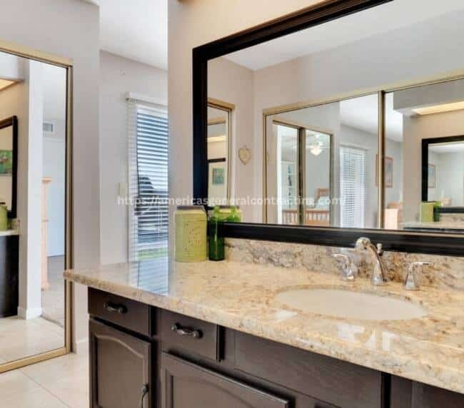Stylish bathroom vanity with granite countertop, large mirror, and decorative accents, highlighting bathroom remodeling Dallas services